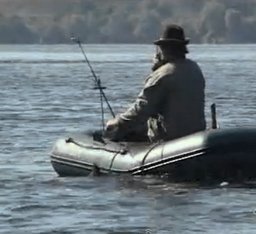 Рыбак в лодке ловит леща